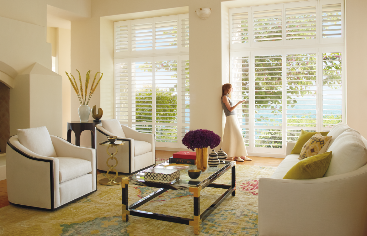 Woman standing in room looking out open blinds